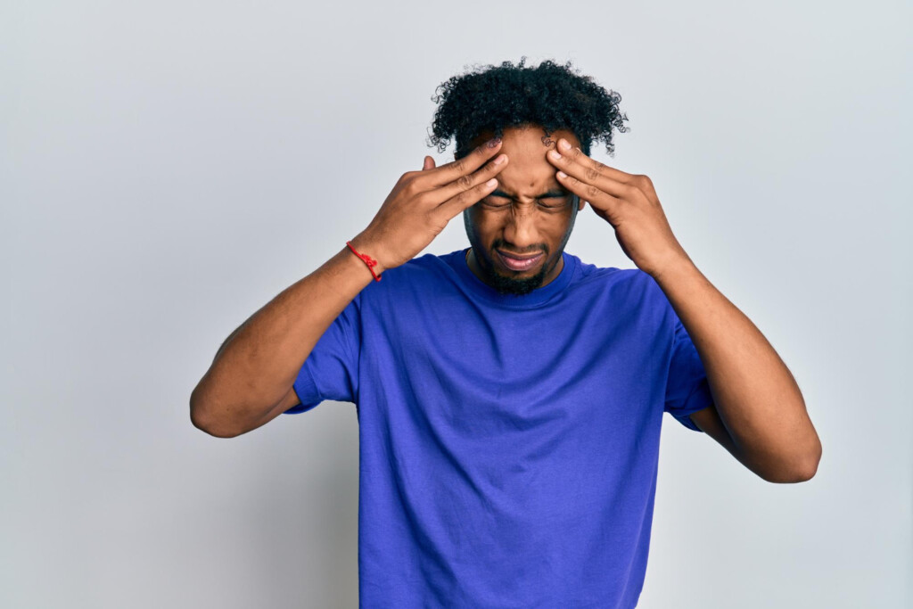 young-african-american-man-with-beard-wearing-casual-blue-t-shirt-with-hand-on-head-headache-because-stress-suffering-migraine